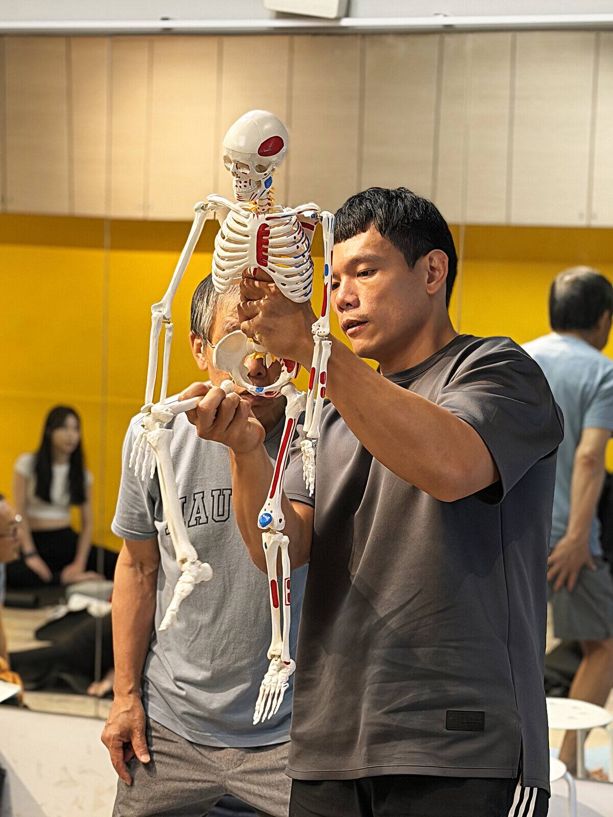 教練使用骨骼模型講解體態調整重點
